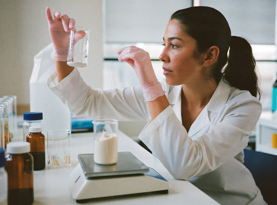Técnica de laboratorio revisando un polvo blanco junto a una balanza de precisión